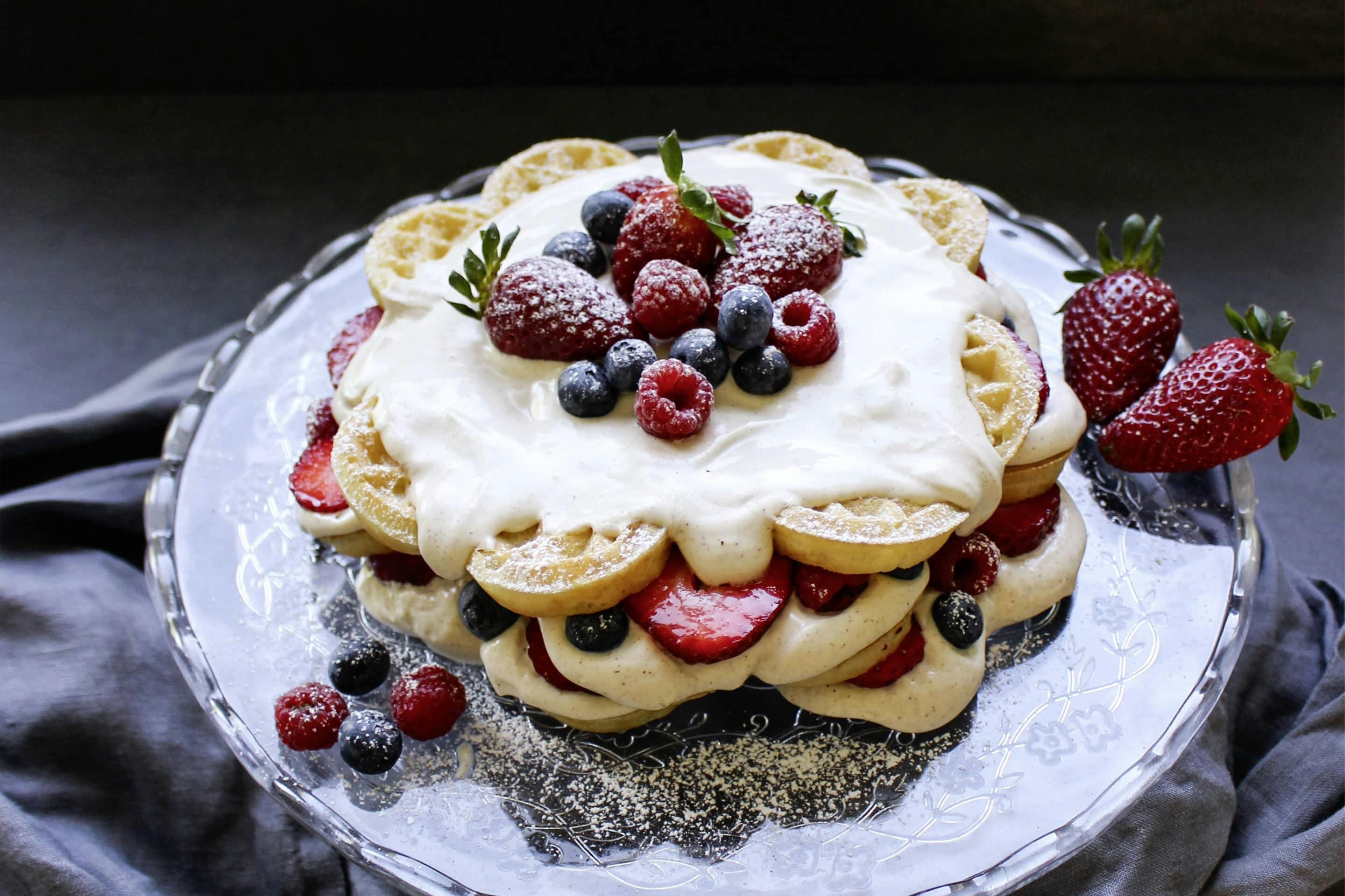 Wafflecake with fresh berries on a glass cake stand