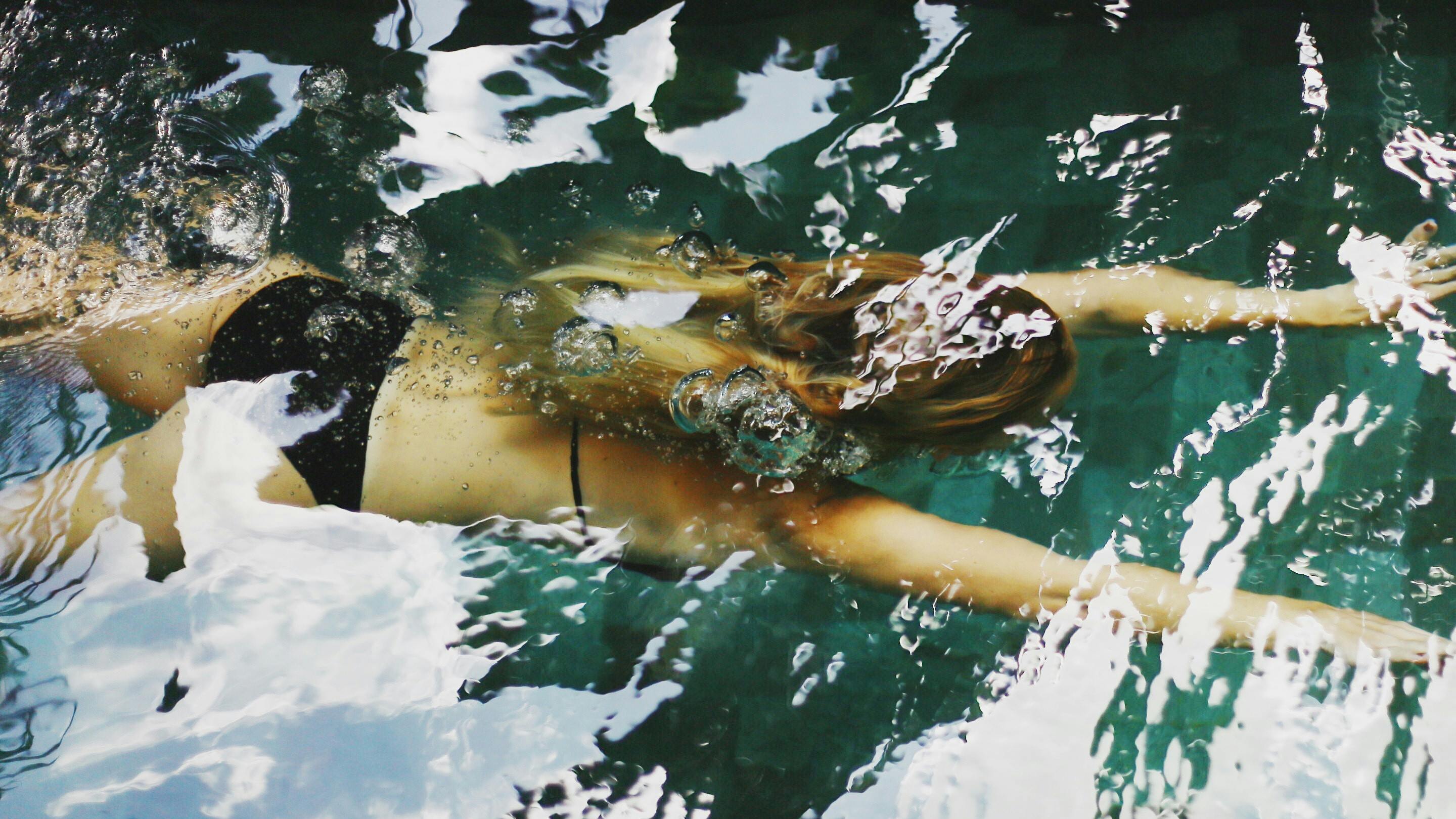 Frau schwimmt in klarem Wasser