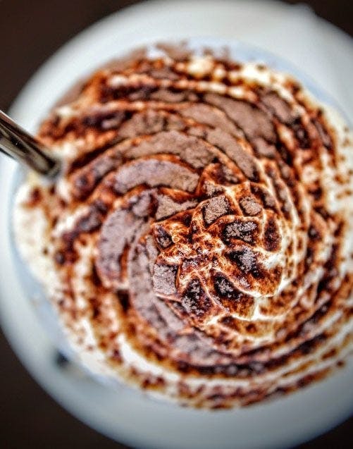 whipped milk on top of coffee topped with spices