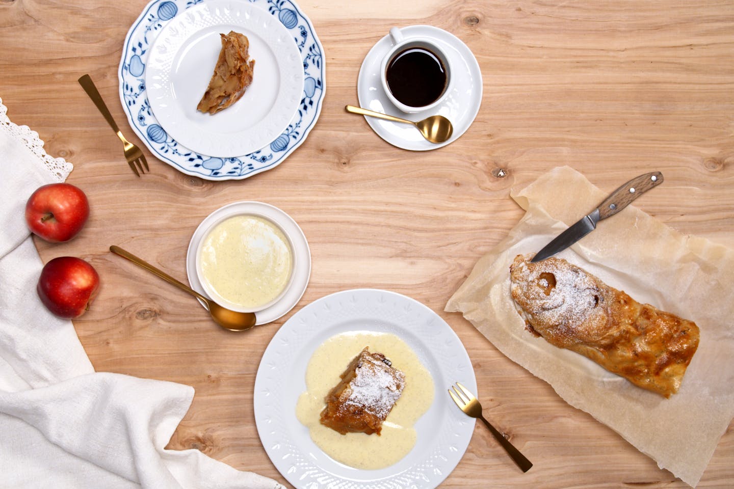 Apple strudel With vanilla sauce on 2 plates, served with coffee and the remaining apple strudel on baking paper