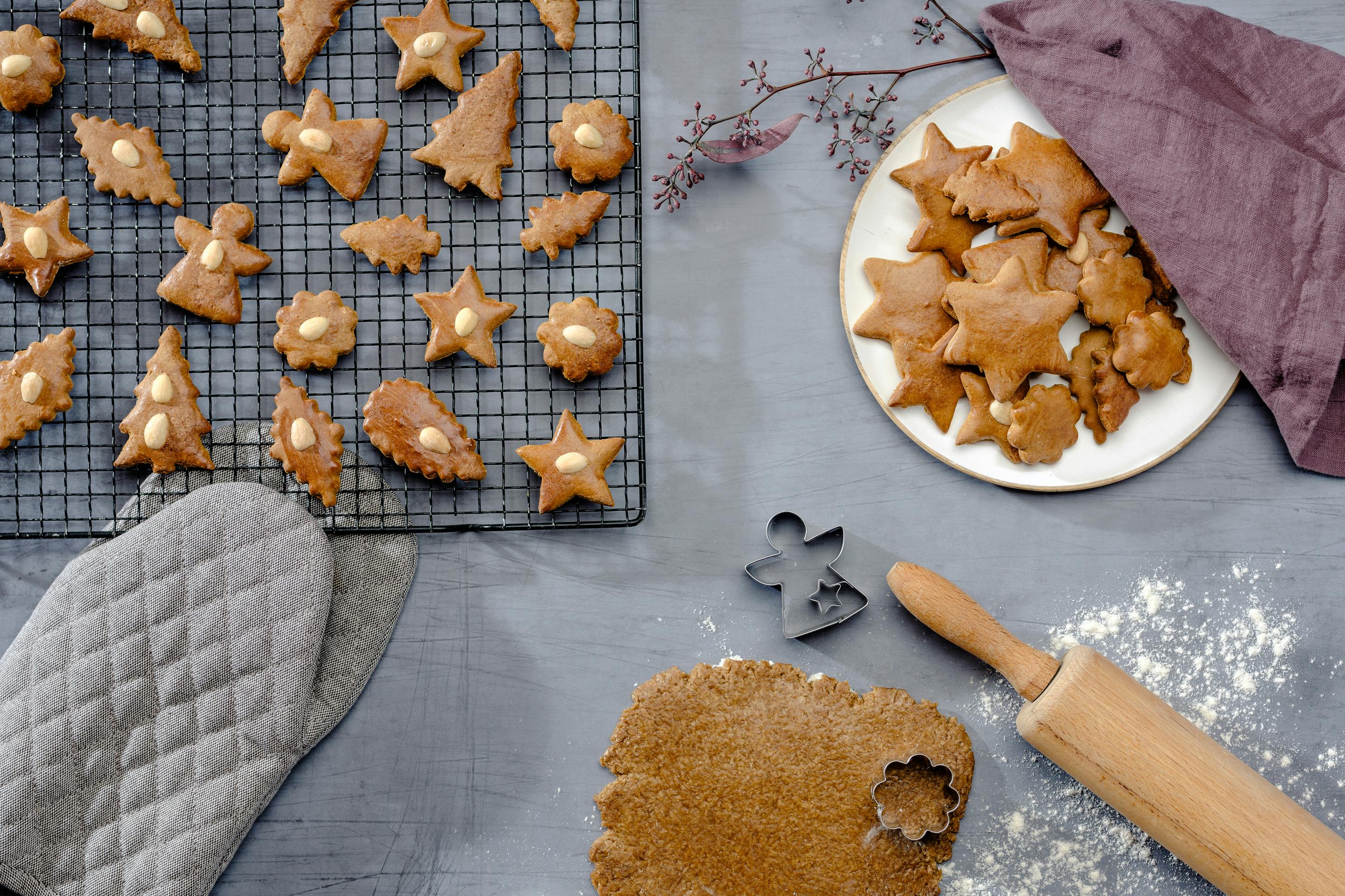 Honey gingerbreads are being cut out of dough and lie on a black wire rack to cool down