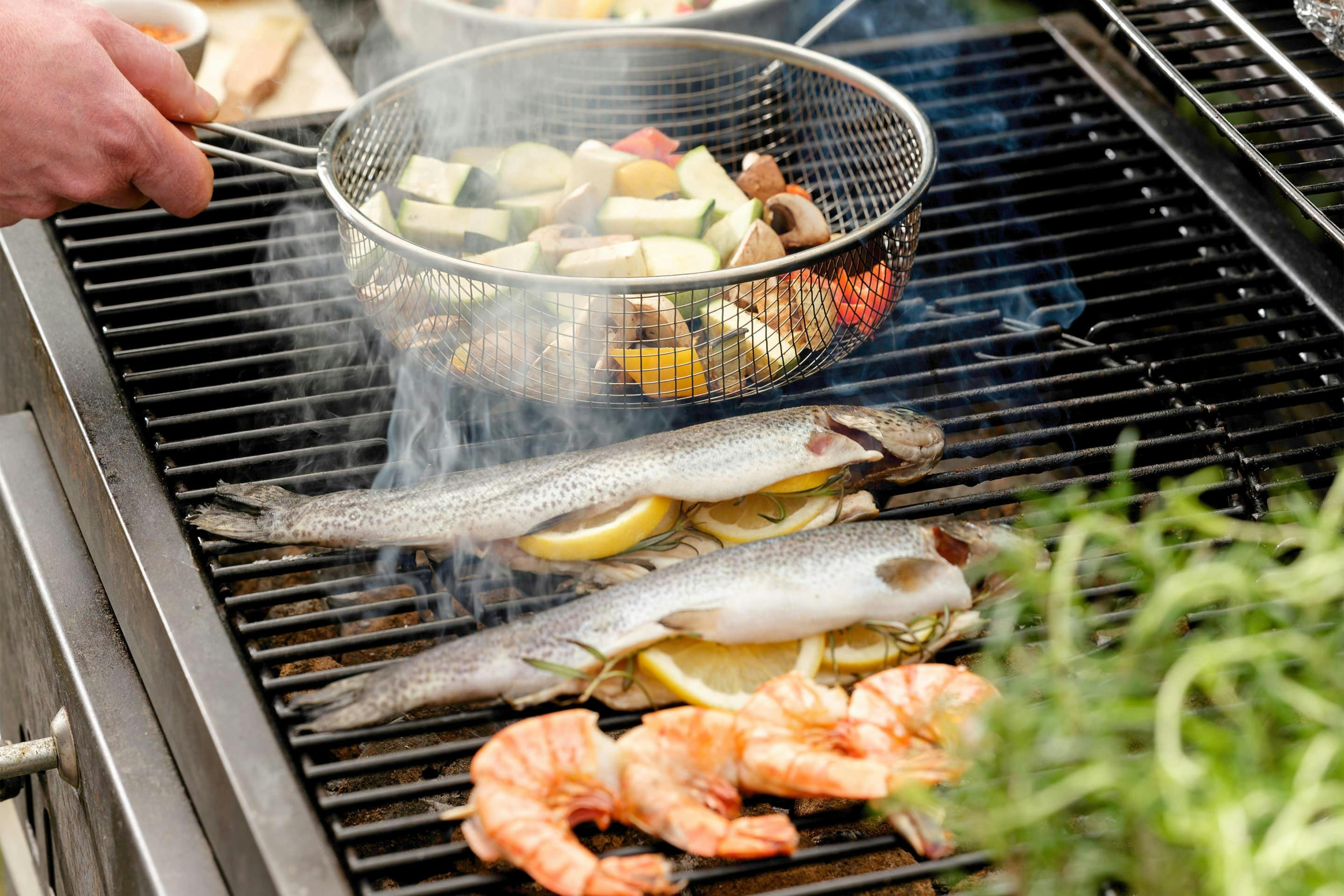 Lemon stuffed trout and vegetables on the grill.