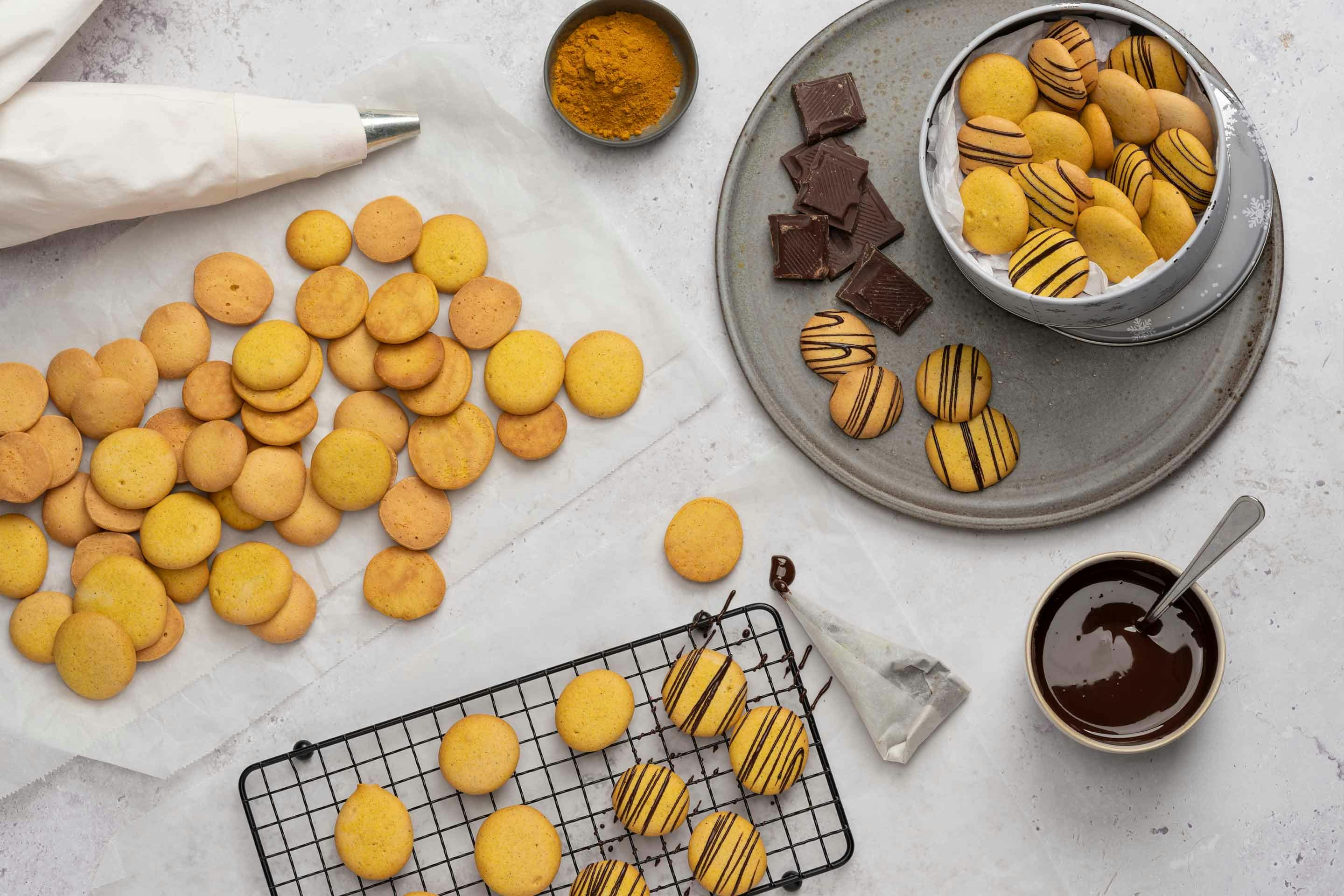 Golden milk buttons being decorated with chocolate.