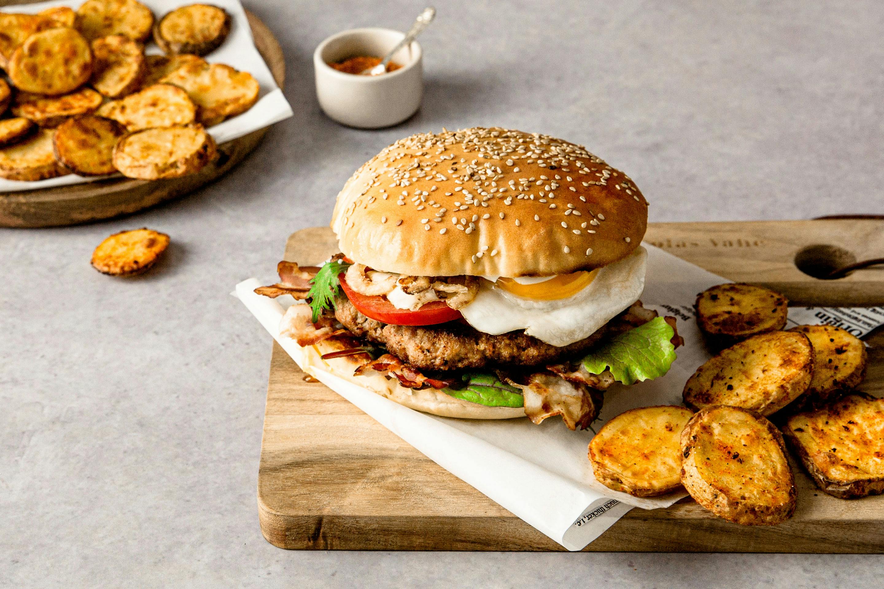 Spicy potatoes with western burger with egg arranged on a board