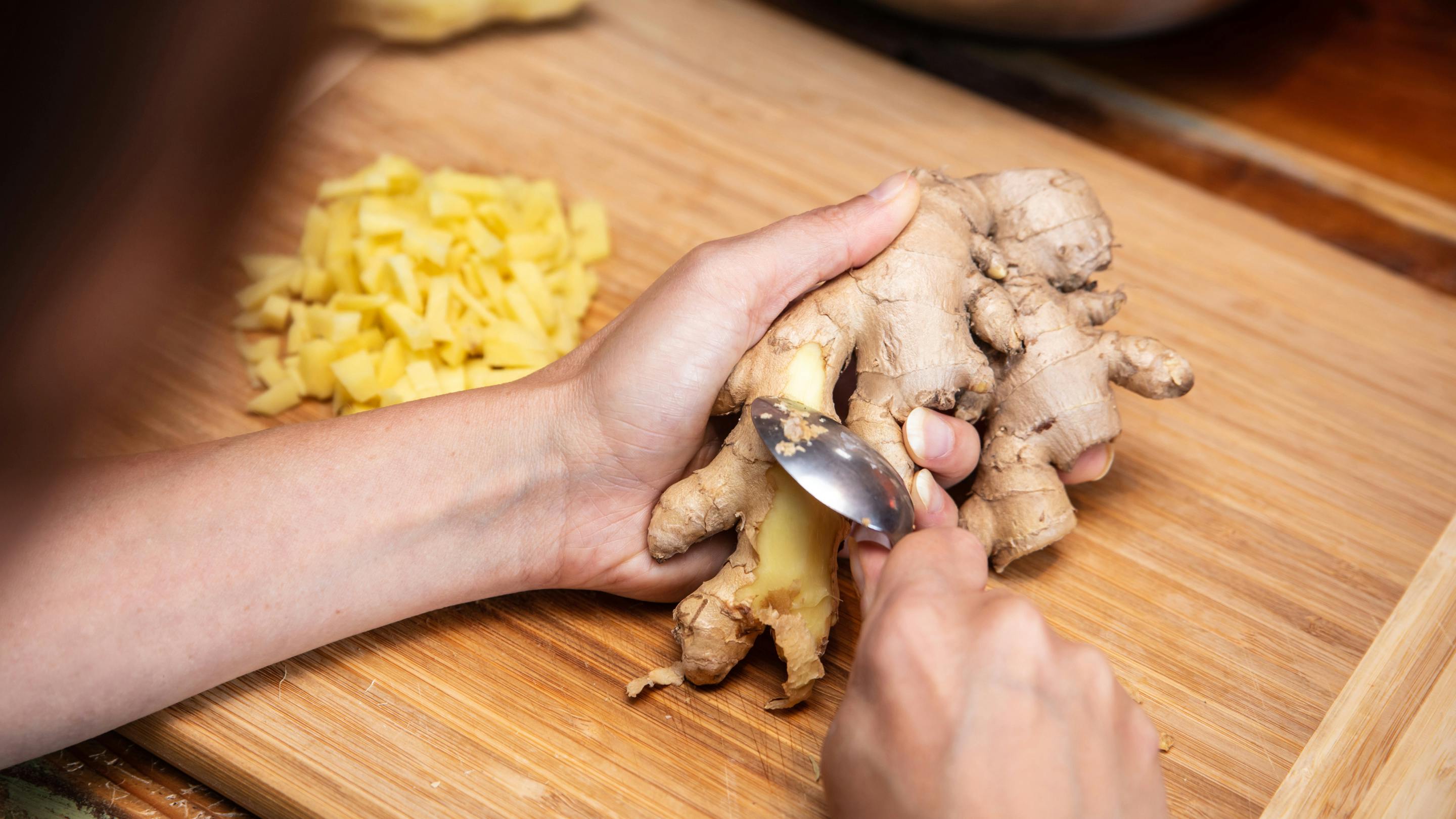Peeling a piece of ginger with a spoon